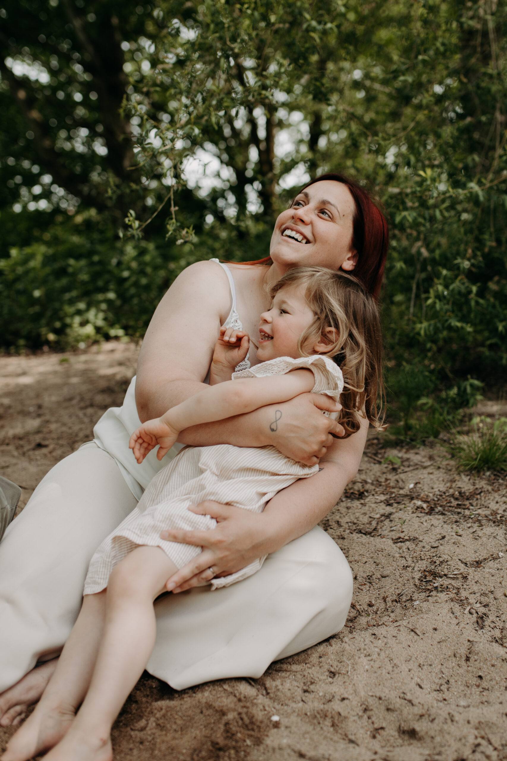 Maman et sa fille qui rient dans l'herbe, séance photo famille à Orléans