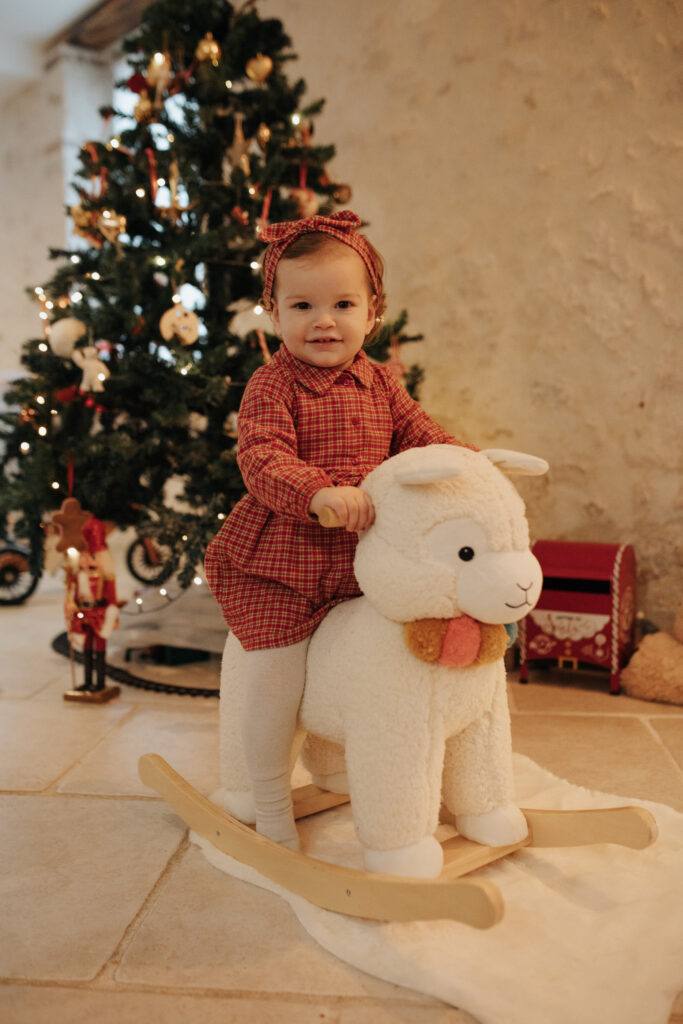 Bébé sur un mouton à bascule, séance photo de Noël dans le Loiret