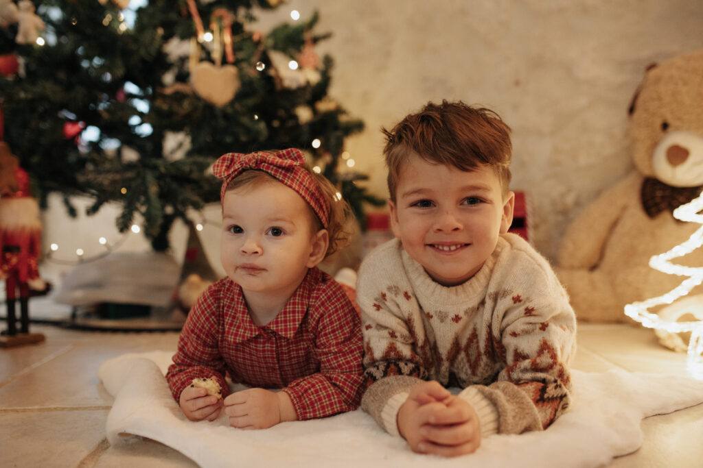 Frère et sœur au pied du sapin, séance photo de Noël à Orléans