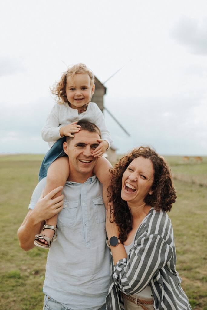 Papa portant sa fille sur les épaules, séance photo famille pleine de rires
