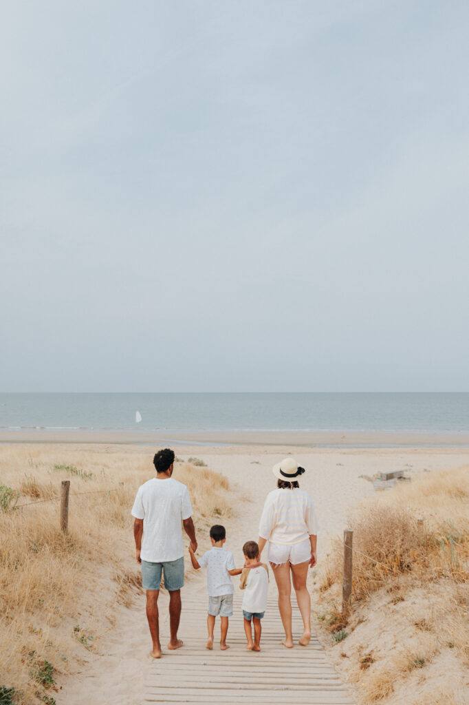 Famille qui marche vers la plage, séance photo famille en bord de mer