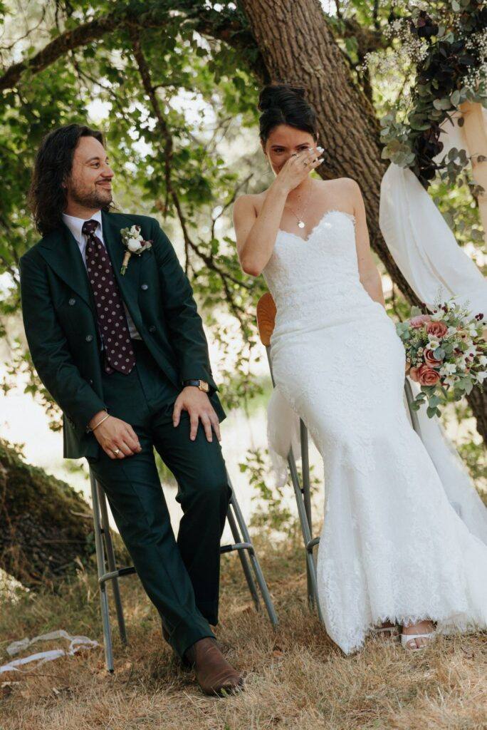 La mariée émue essuie une larme à côté du marié pendant la cérémonie laïque au Domaine de la Volière