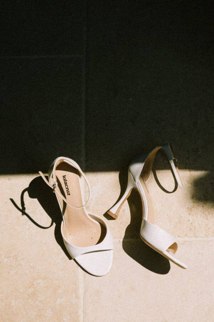 Chaussures de la mariée posées sur un tapis ancien pendant les préparatifs au Domaine de la Volière