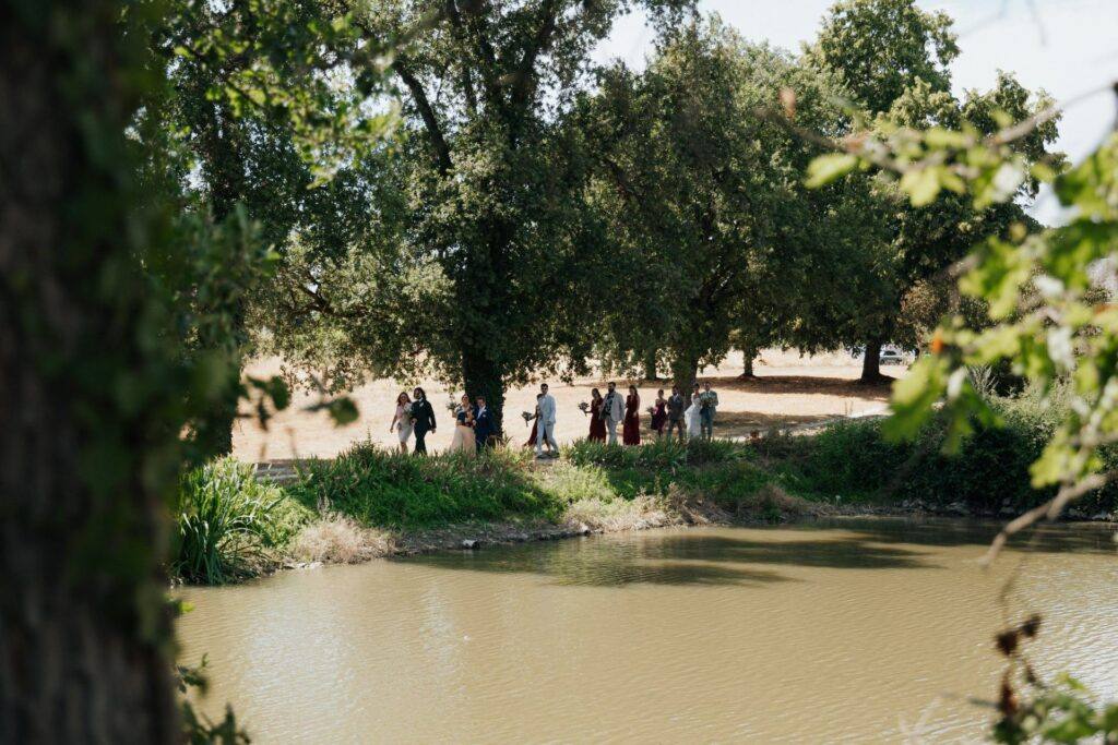 Le cortège marche sous les arbres au bord de l'étang vers la cérémonie laïque, Domaine de la Volière
