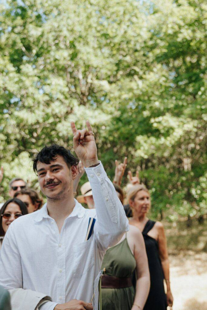 Invités qui font les cornes du rock pendant la cérémonie laïque au Domaine de la Volière