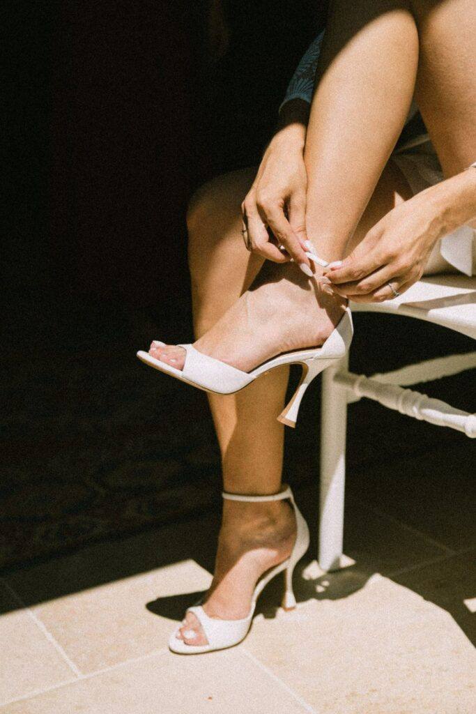 La mariée attache ses chaussures pendant les préparatifs au Domaine de la Volière