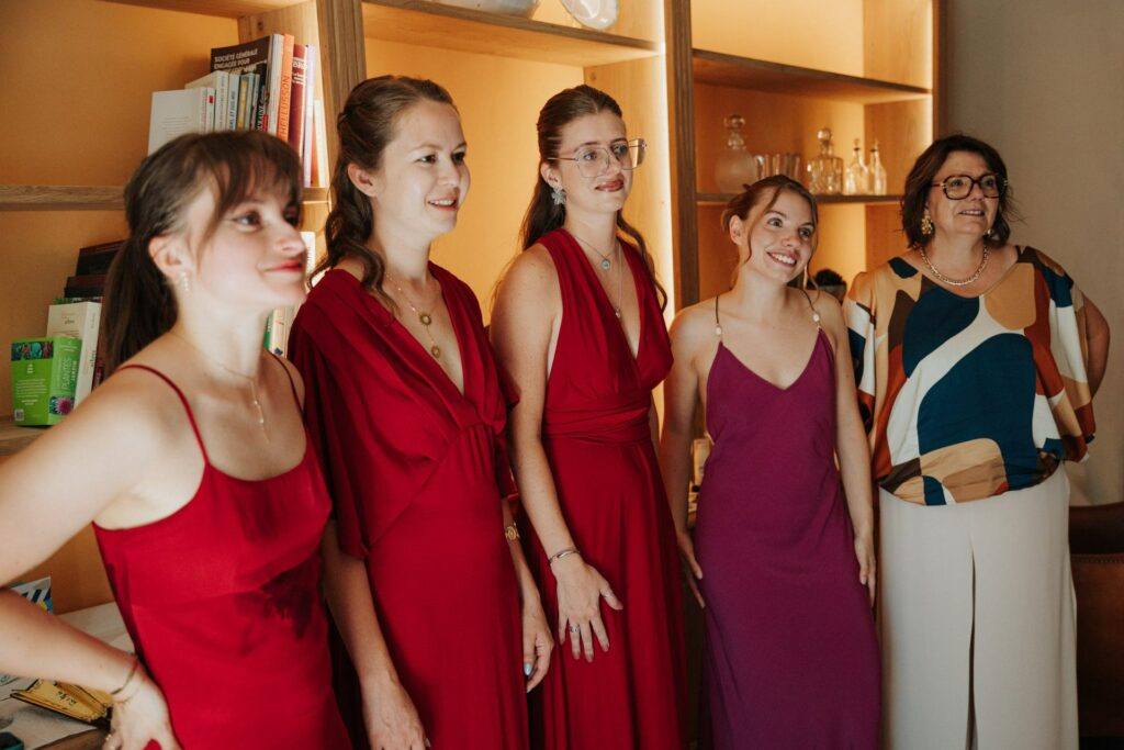 Réaction émue des témoins et demoiselles d'honneur en rouge découvrant la mariée, Domaine de la Volière