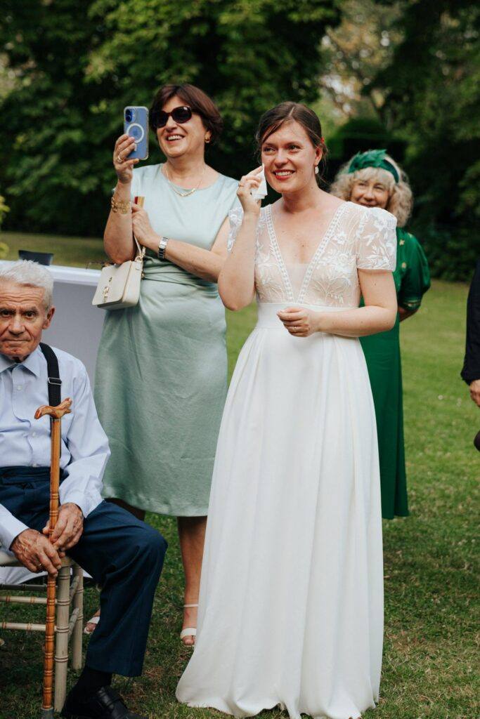 La mariée émue essuie une larme pendant les discours du vin d'honneur au Manoir du Grand Courtoiseau