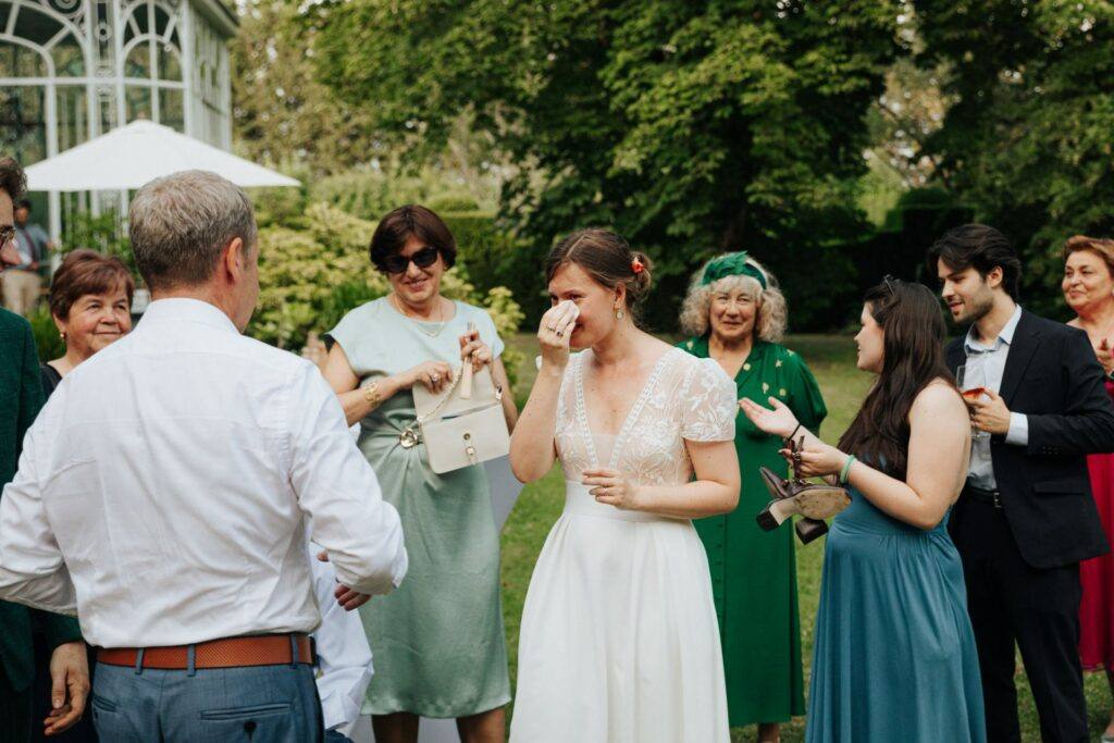 La mariée émue entourée de ses invités pendant le vin d'honneur au Manoir du Grand Courtoiseau