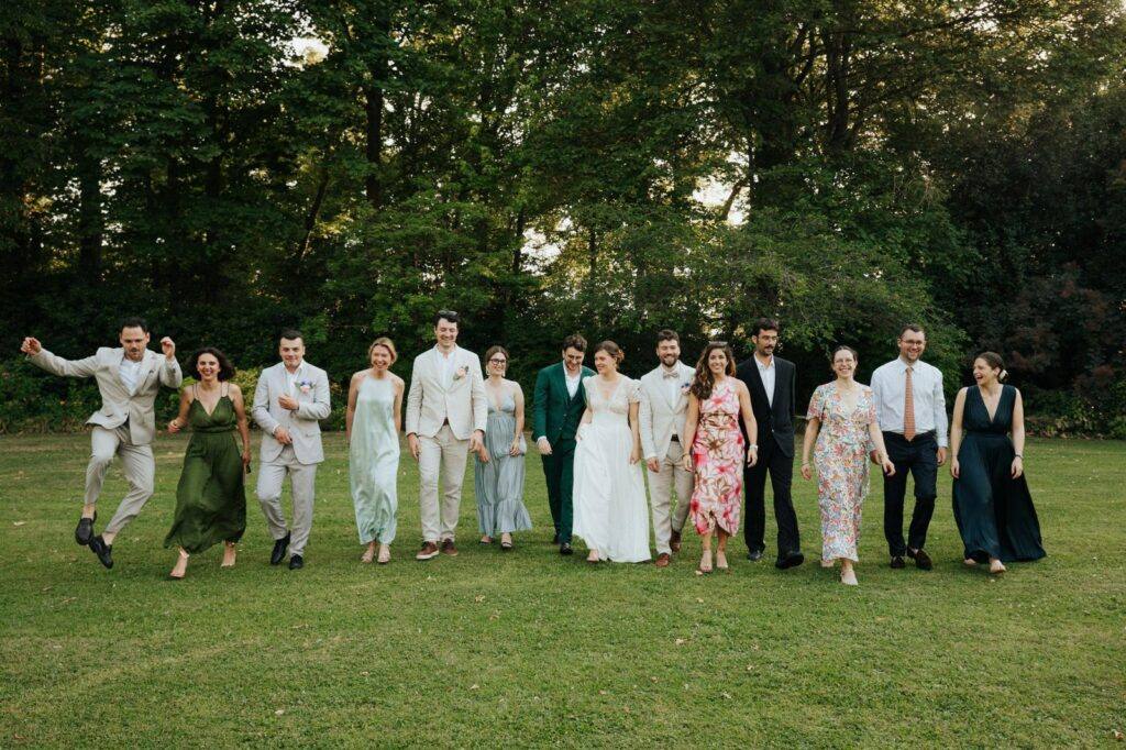 Photo de groupe joyeuse des mariés et de leurs amis dans le parc du Manoir du Grand Courtoiseau