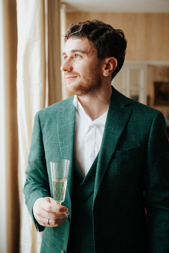 Portrait du marié en costume vert pendant ses préparatifs à Orléans