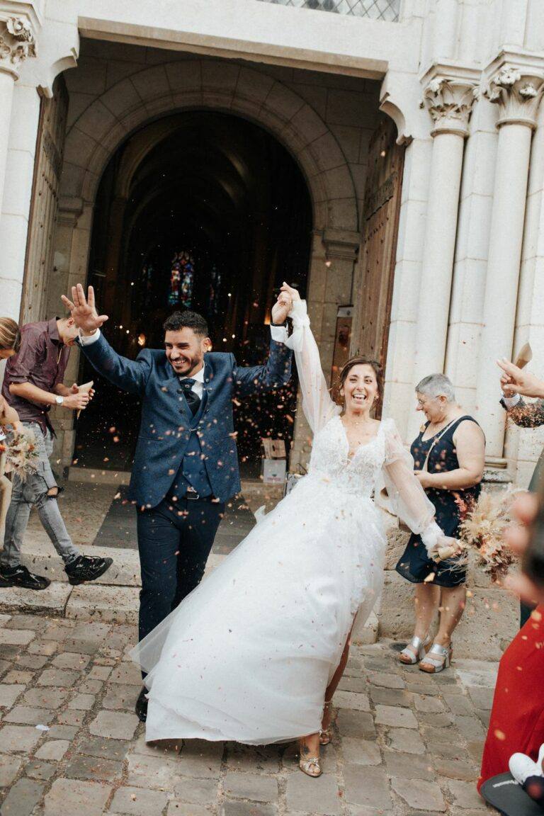 Mariés sortant de l'église d'Olivet sous une pluie de confettis, photographe de mariage à Orléans Clara Valette