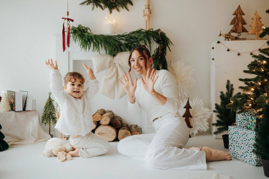 Maman et sa fille en tenues blanches devant un décor de Noël, séance photo de Noël à Orléans